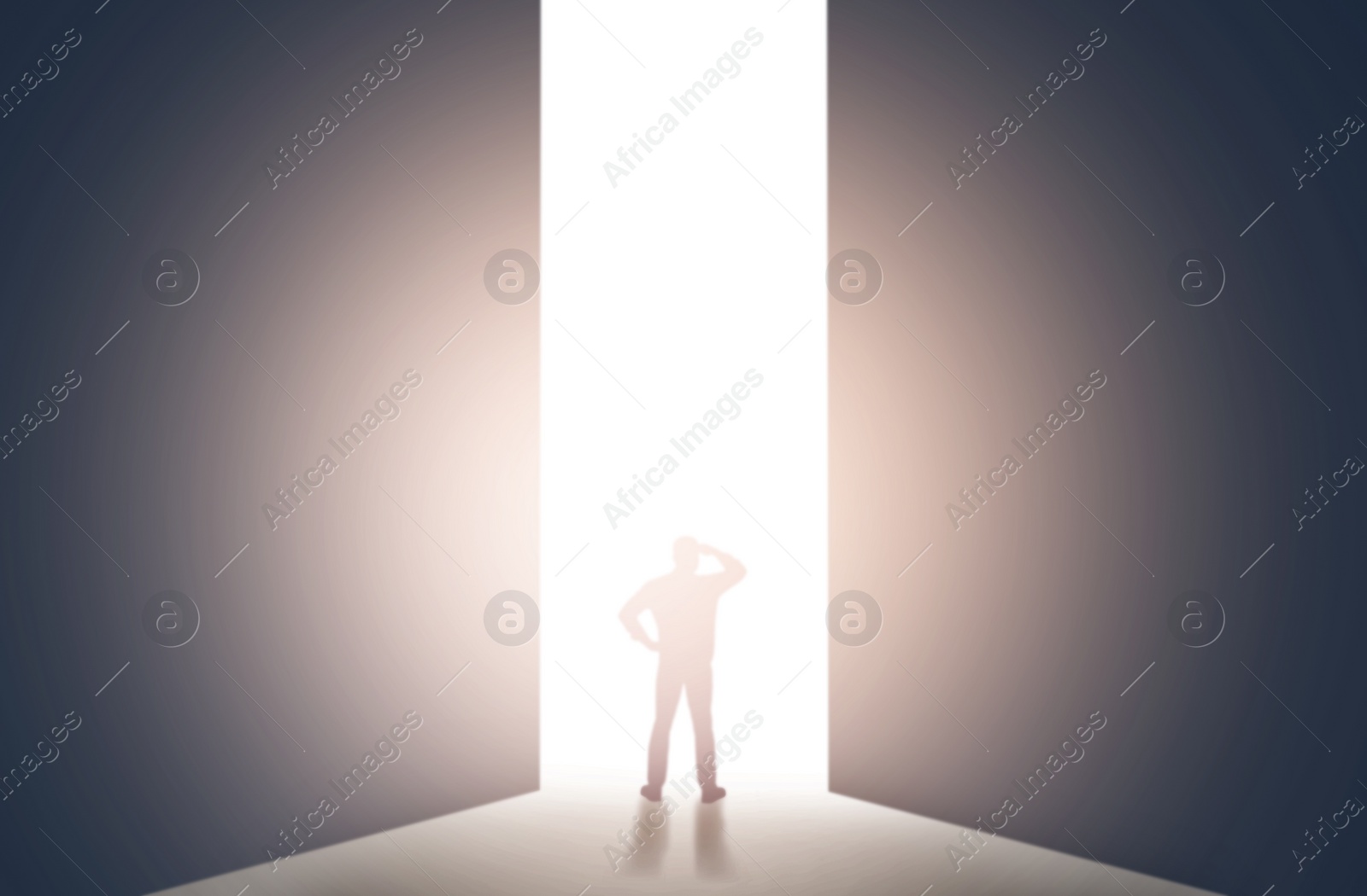 Image of Silhouette of man standing in front of light hole, back view