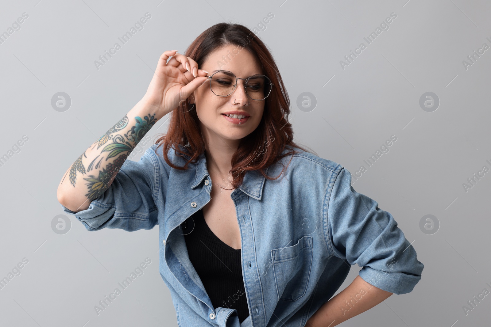 Photo of Portrait of beautiful tattooed woman on gray background