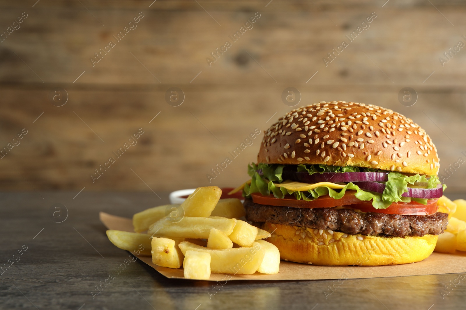 Photo of Burger with delicious patty and french fries on table, space for text