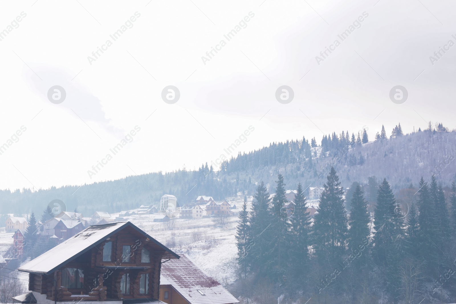 Photo of Beautiful view of snowy valley with buildings on winter day