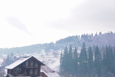 Beautiful view of snowy valley with buildings on winter day