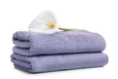 Photo of Clean folded towels with flower on white background