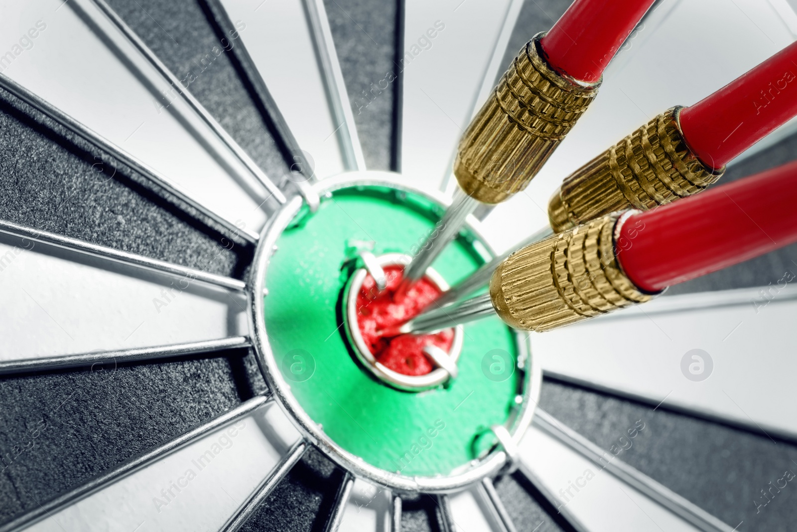 Photo of Dart board with red arrows hitting target, closeup