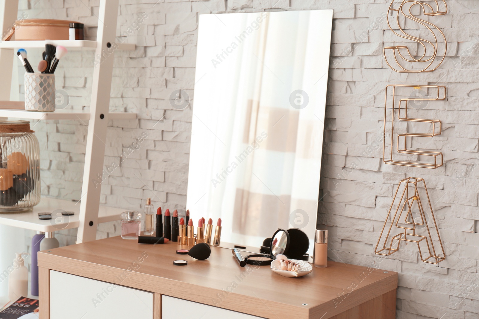 Photo of Decorative cosmetics and tools on dressing table near mirror in makeup room