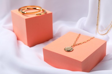 Photo of Stylish presentation of bracelets and necklace on white cloth