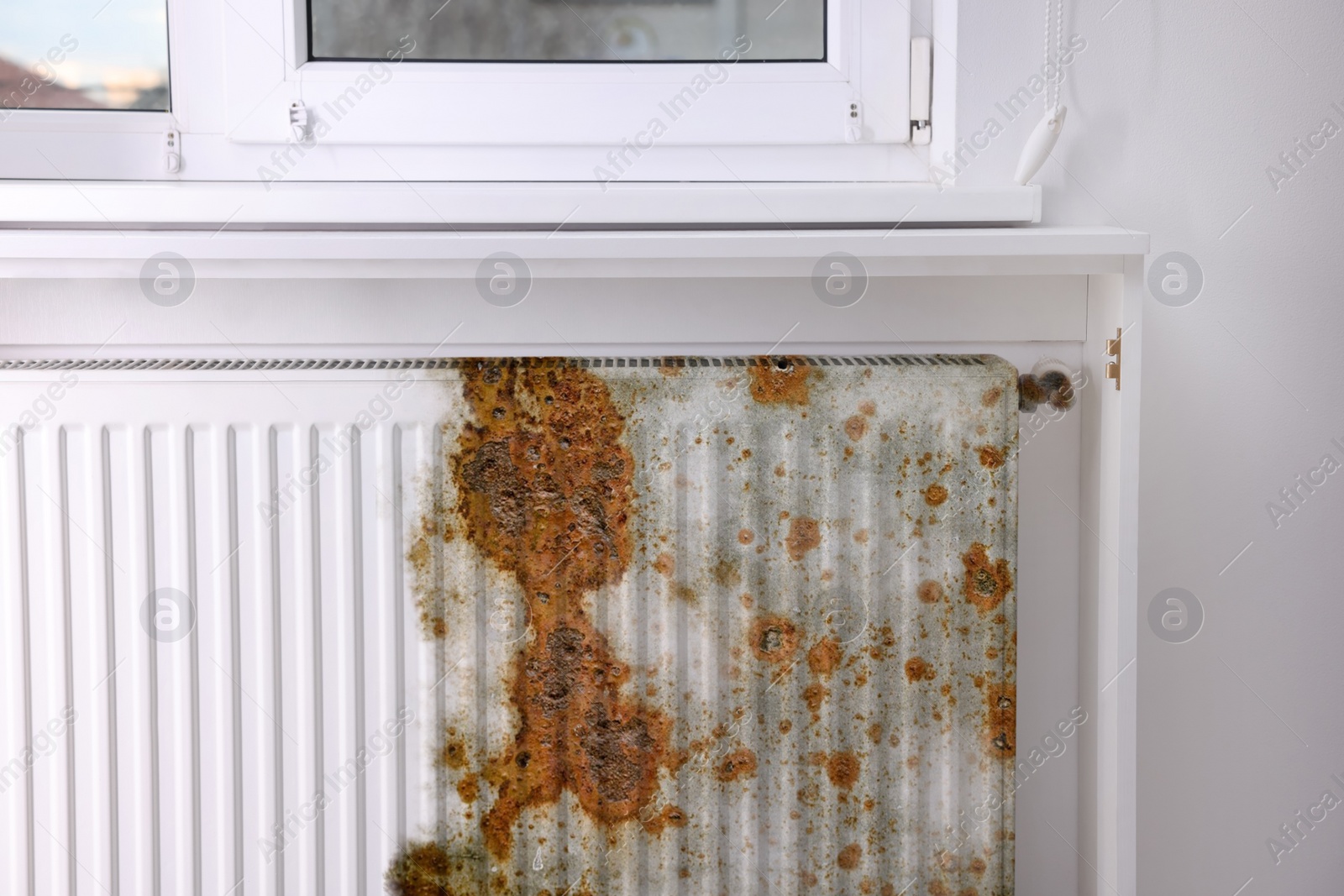 Image of Modern panel radiator affected by rust indoors