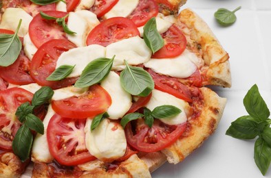 Photo of Delicious Caprese pizza with tomatoes, mozzarella and basil on white table, closeup