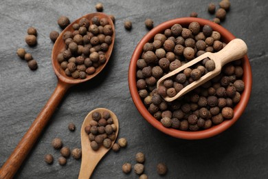 Photo of Dry allspice berries (Jamaica pepper) on black table, top view