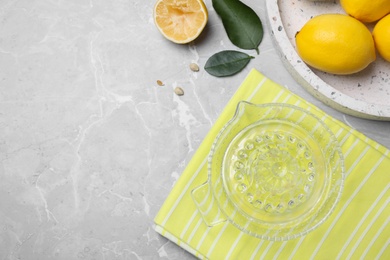 Flat lay composition with freshly squeezed lemon juice on grey table. Space for text