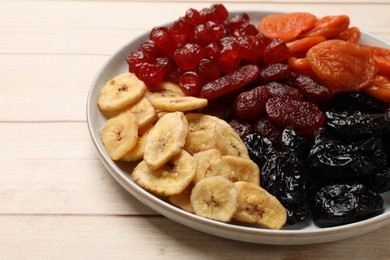 Delicious dried fruits on white wooden table, closeup