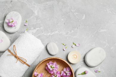 Flat lay composition with spa stones on light grey marble table, space for text