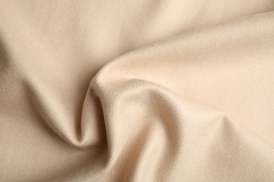 Beige soft cashmere fabric as background, closeup