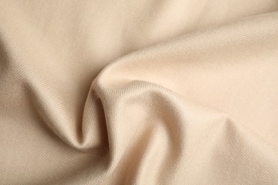 Photo of Beige soft cashmere fabric as background, closeup