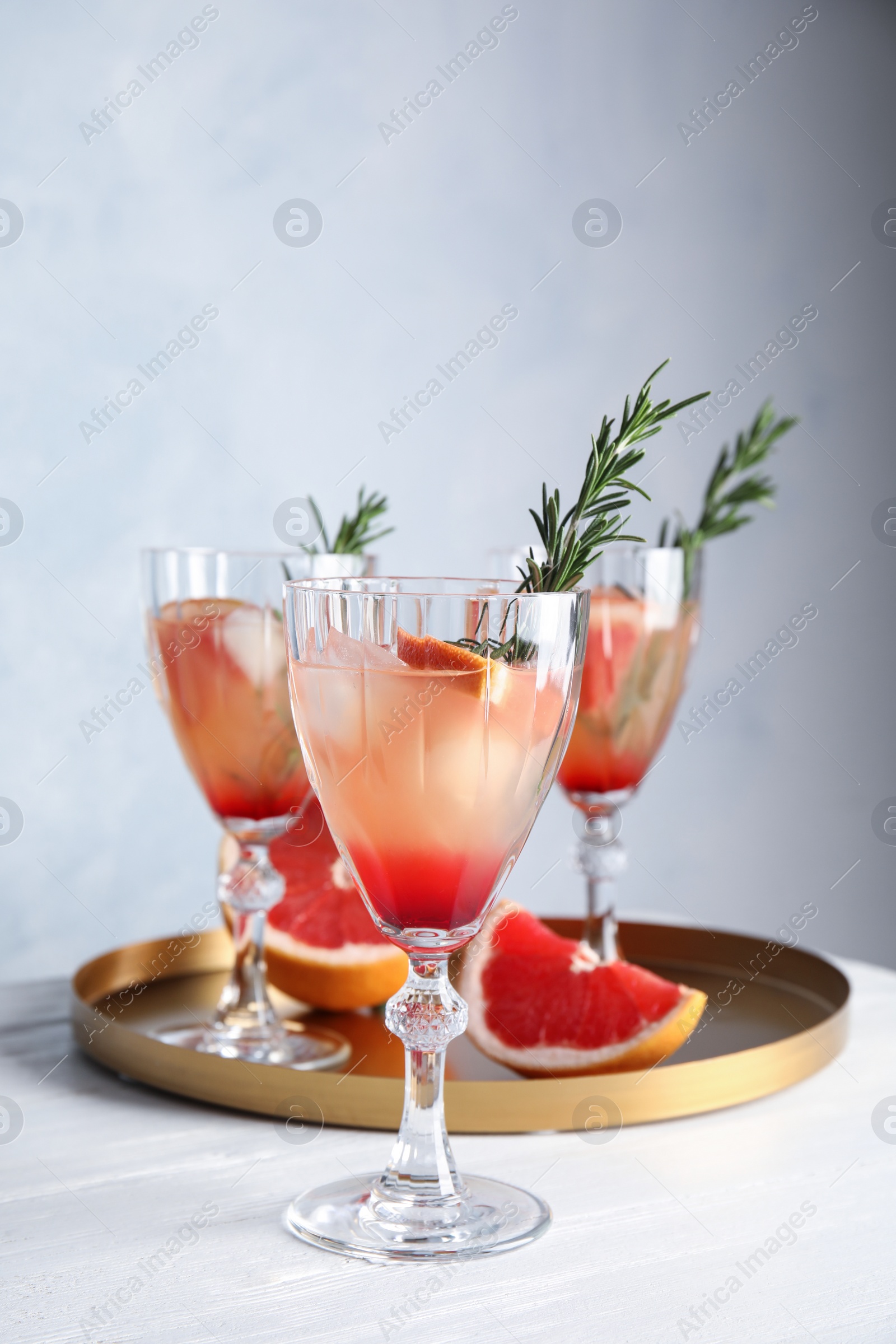 Photo of Glasses of grapefruit cocktails on table. Space for text