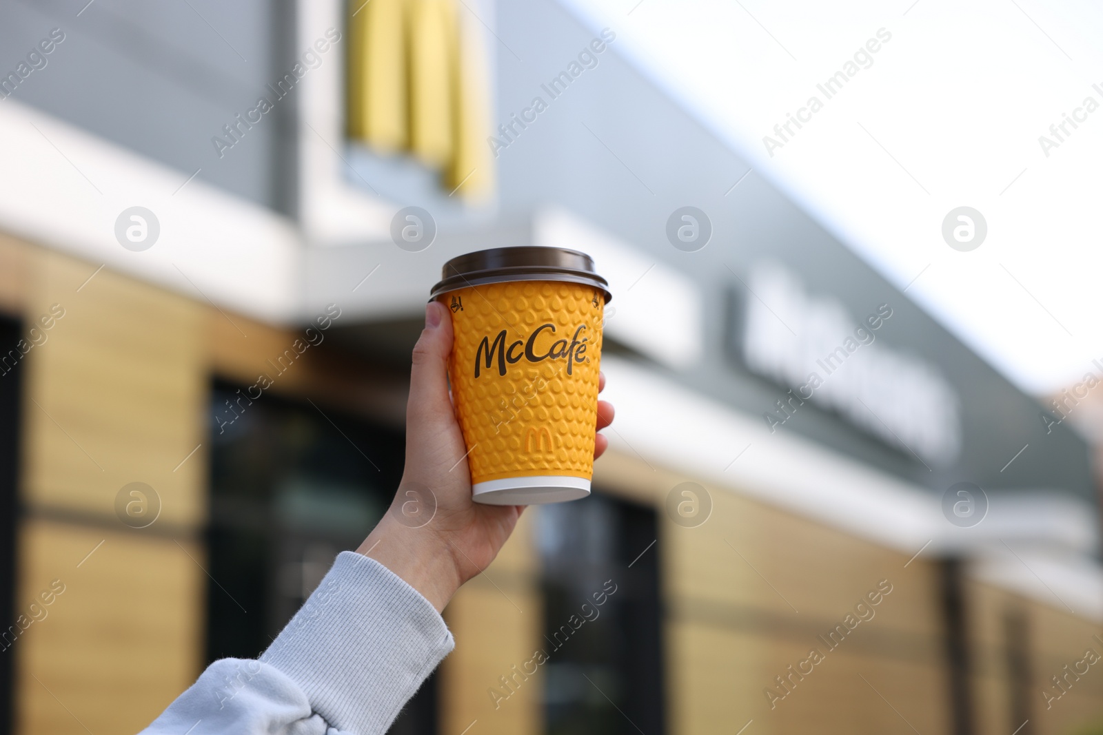 Photo of Lviv, Ukraine - September 26, 2023: Woman with hot McDonald's drink outdoors, closeup. Space for text