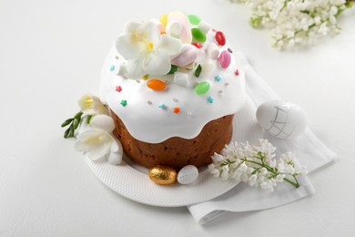 Photo of Traditional Easter cake with sprinkles, jelly beans, marshmallows and decorated eggs on white table
