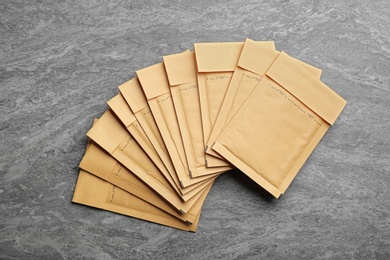 Photo of Many kraft paper envelopes on grey background, flat lay