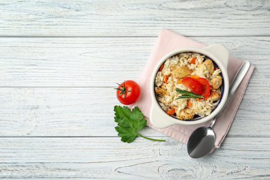 Photo of Delicious chicken risotto served on white wooden table, flat lay. Space for text