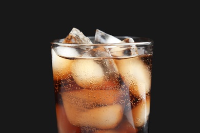 Glass of tasty refreshing cola with ice cubes on black background, closeup