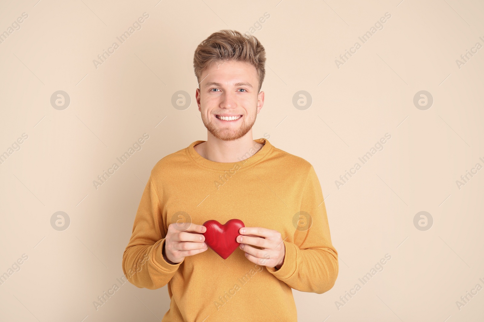 Photo of Portrait of young man with decorative heart on color background