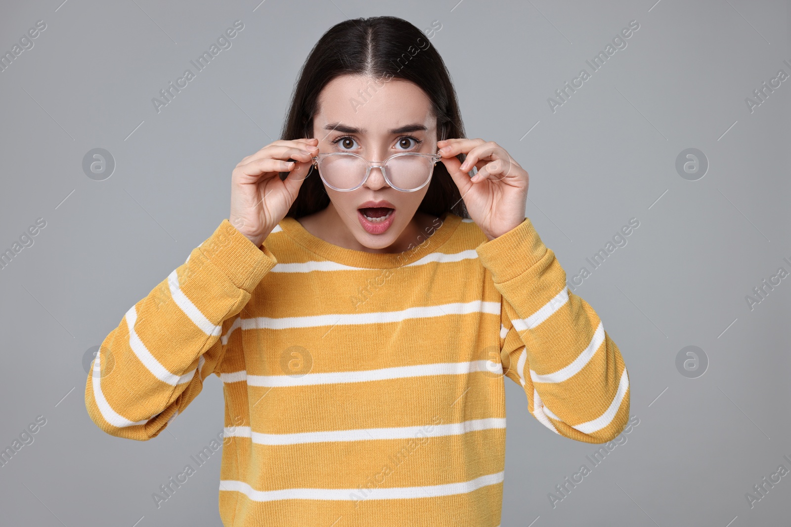 Photo of Portrait of surprised woman on grey background