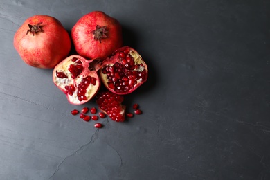 Photo of Ripe pomegranates on grey background, top view with space for text