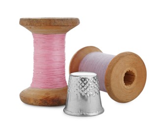 Photo of Thimble and spools of sewing threads isolated on white