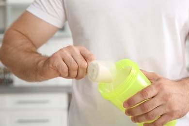 Photo of Man preparing protein shake in kitchen, closeup