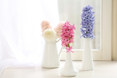 Photo of Beautiful fresh hyacinths on window sill indoors. Spring flowers