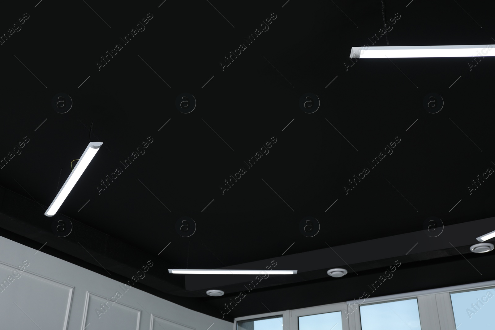 Photo of Black ceiling with modern lighting in office