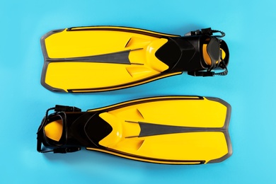 Photo of Pair of yellow flippers on color background, top view