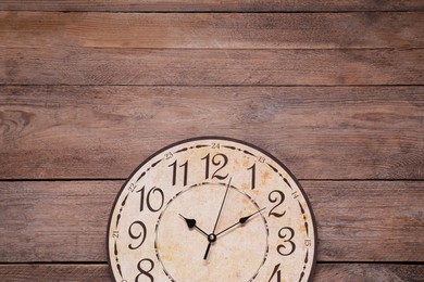 Stylish round clock on wooden table, top view with space for text. Interior element