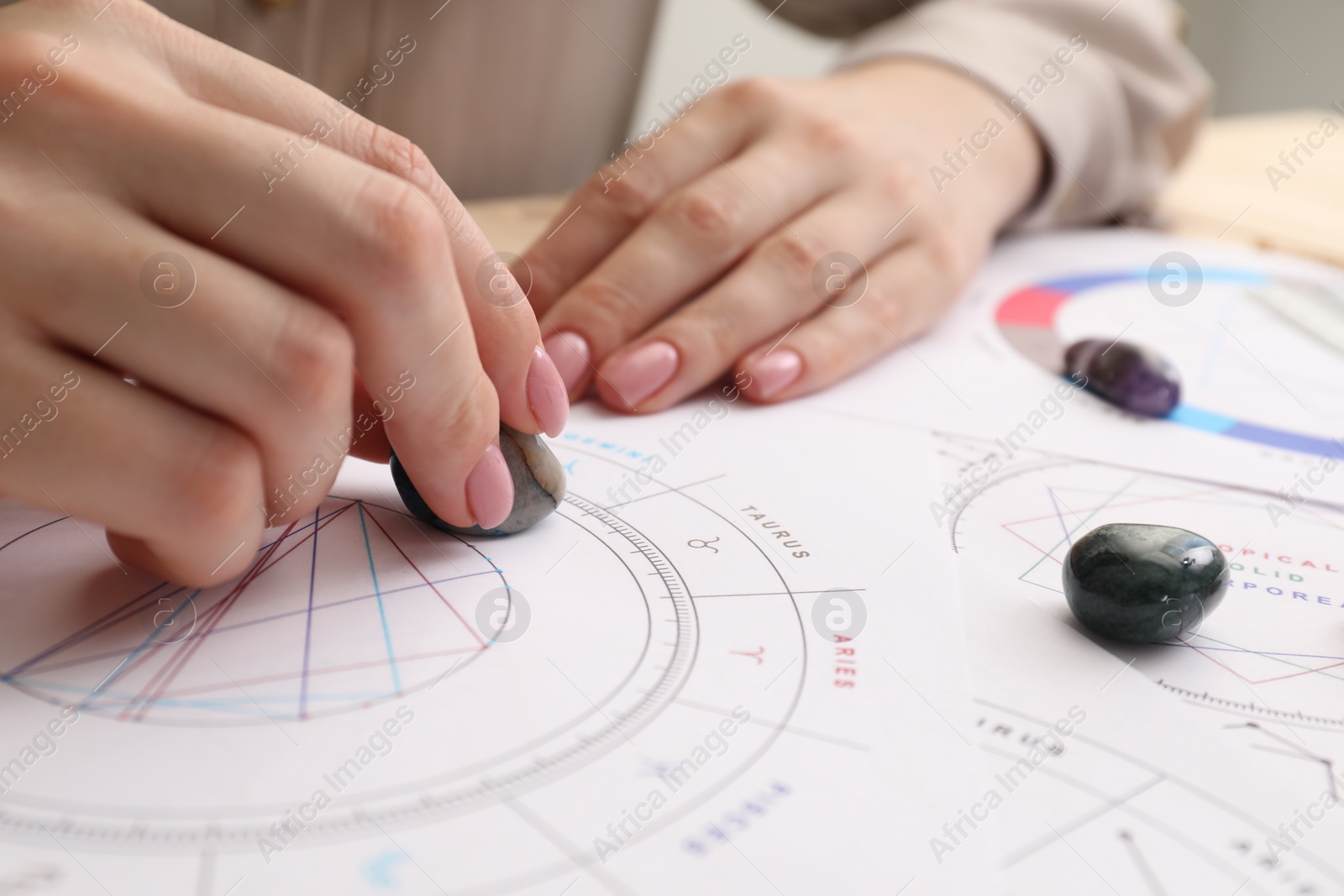 Photo of Astrologer using natal chart for making forecast of fate at table, closeup. Fortune telling