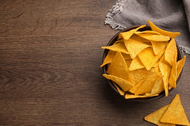 Photo of Tortilla chips (nachos) on wooden table, flat lay. Space for text