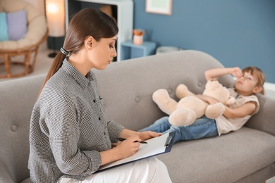 Female psychologist working with cute little girl in office