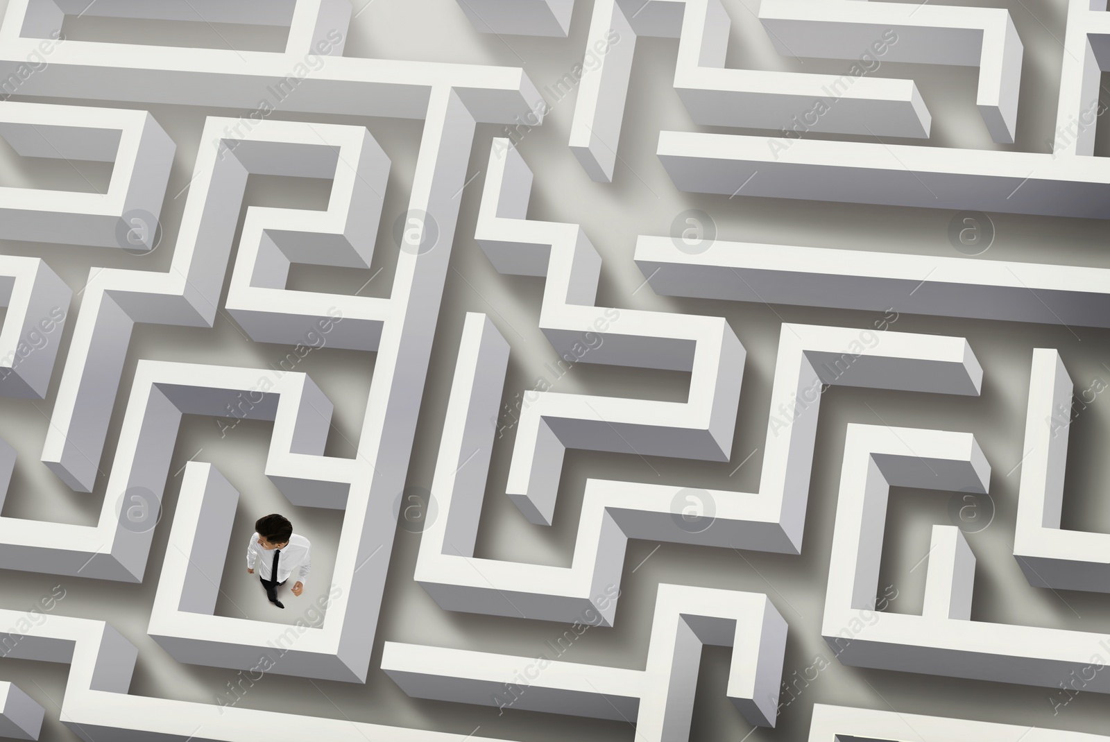 Image of Thoughtful businessman trying to find way out of maze, above view