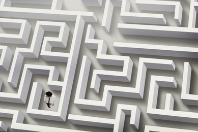 Image of Thoughtful businessman trying to find way out of maze, above view