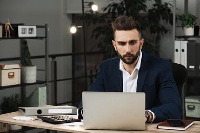 Photo of Man working on laptop at table in office, space for text