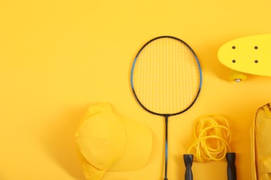 Different sports equipment on yellow background, flat lay. Space for text