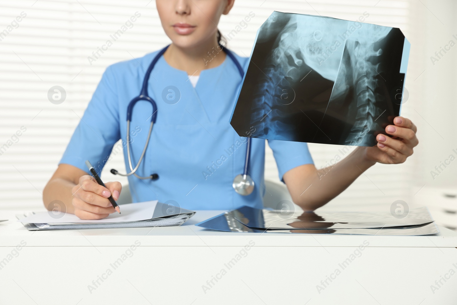 Photo of Doctor examining neck MRI image in clinic, closeup