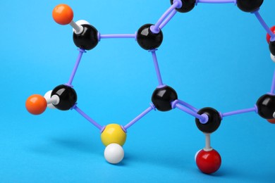 Structure of molecule on light blue background, closeup. Chemical model