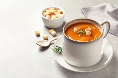 Photo of Mug of tasty sweet potato soup served on table. Space for text