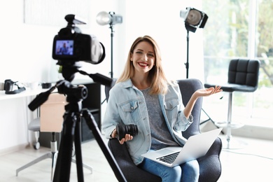 Photo of Female photo blogger recording video on camera indoors
