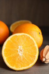 Photo of Cut fresh ripe orange on wooden table, closeup