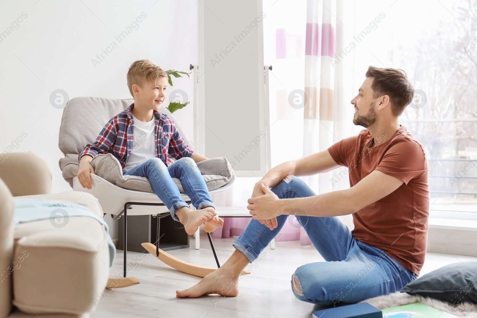 Photo of Little boy and his dad spending time together at home