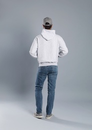 Photo of Young man in sweater on grey background. Mock up for design
