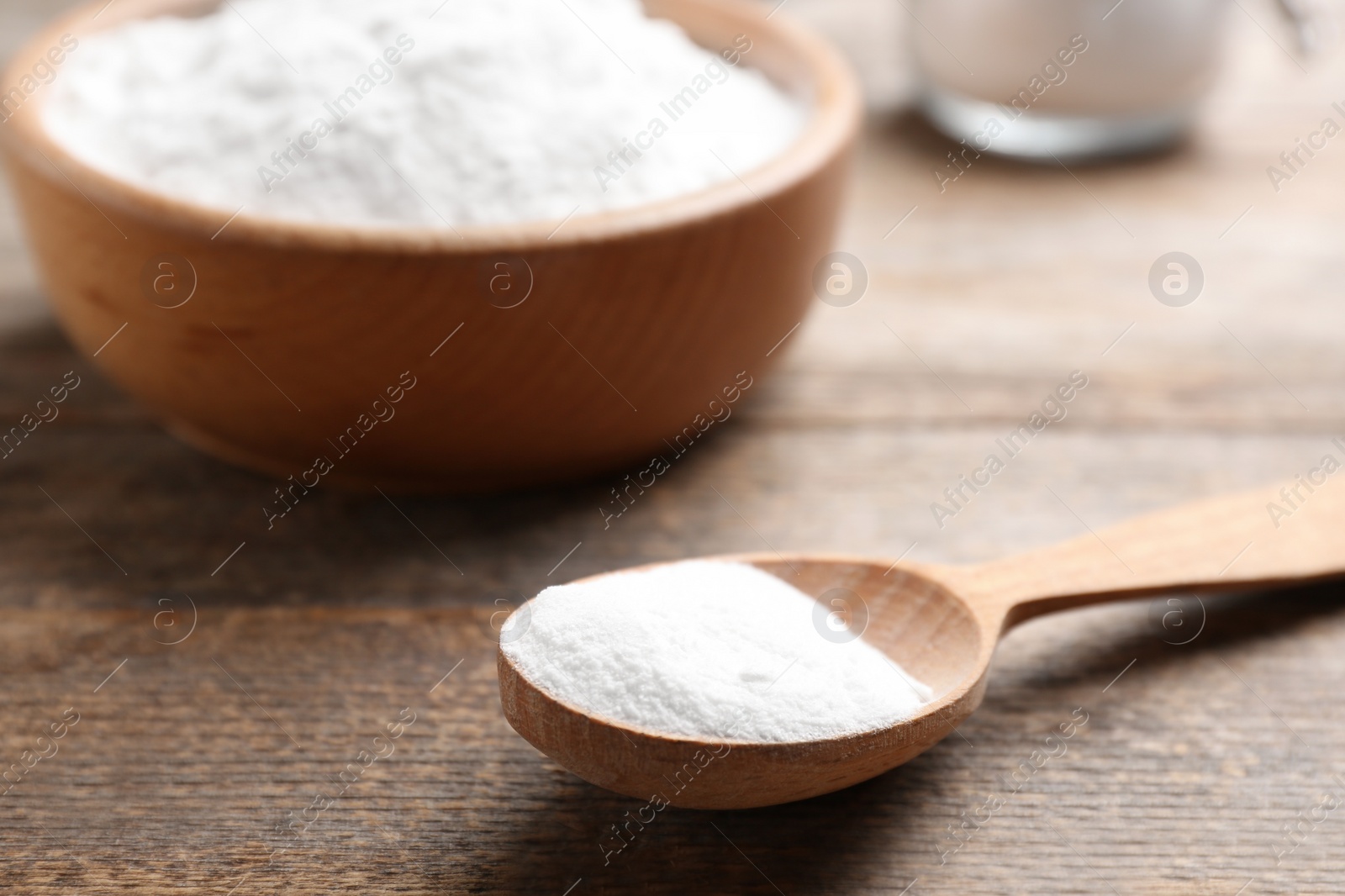 Photo of Spoon with baking soda on wooden table