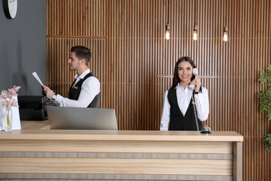 Photo of Receptionists working at desk in modern lobby