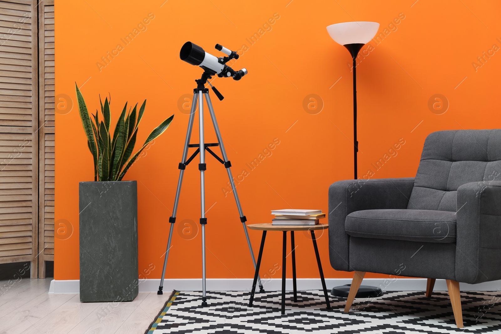 Photo of Tripod with modern telescope in stylish room