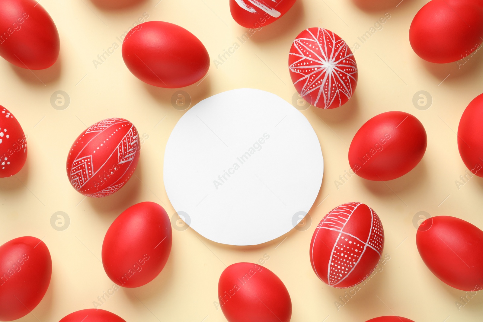 Photo of Flat lay composition of painted red Easter eggs and card on color background, space for text